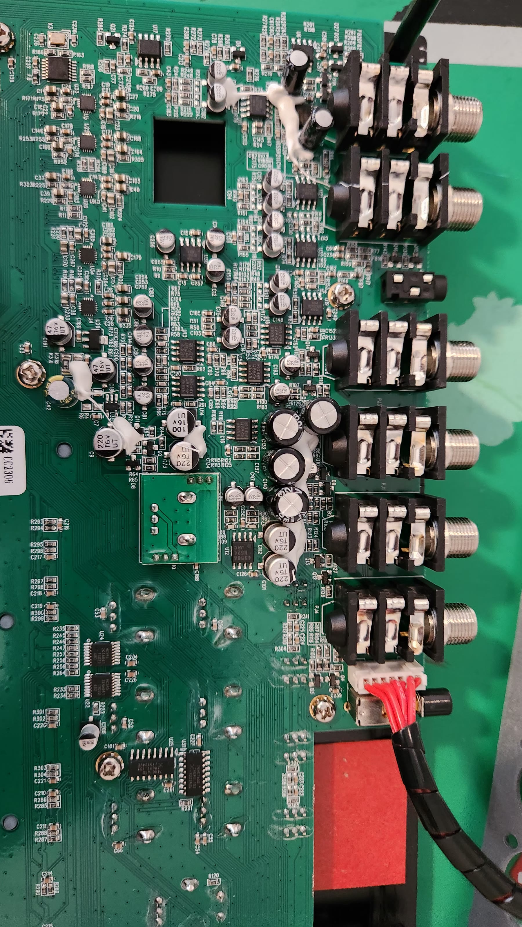 Audio input and output section with quarter-inch jacks and capacitors secured by white adhesive