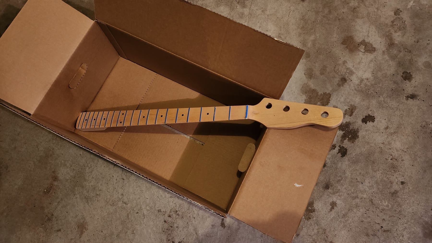Bass guitar headstock fitted with open-gear tuning machines
